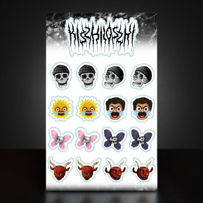 A photo of a Kiszkiloszki sticker sheet. The stickers include designs such as smiling skulls wearing beanies, an angry-sad sun with big blue tears, an angry-sad man with big blue tears, skulls with butterfly wings, and cute little red devil heads with horns. Plus a sticker of Kiszkiloszki logo designed in the style of a metal band.